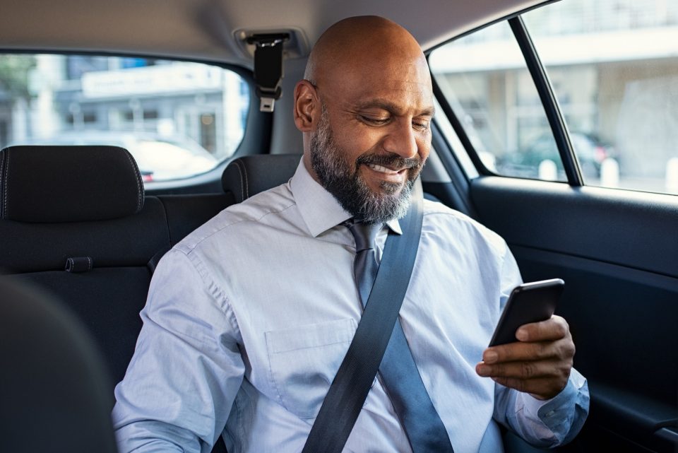 Mature business man using phone in car